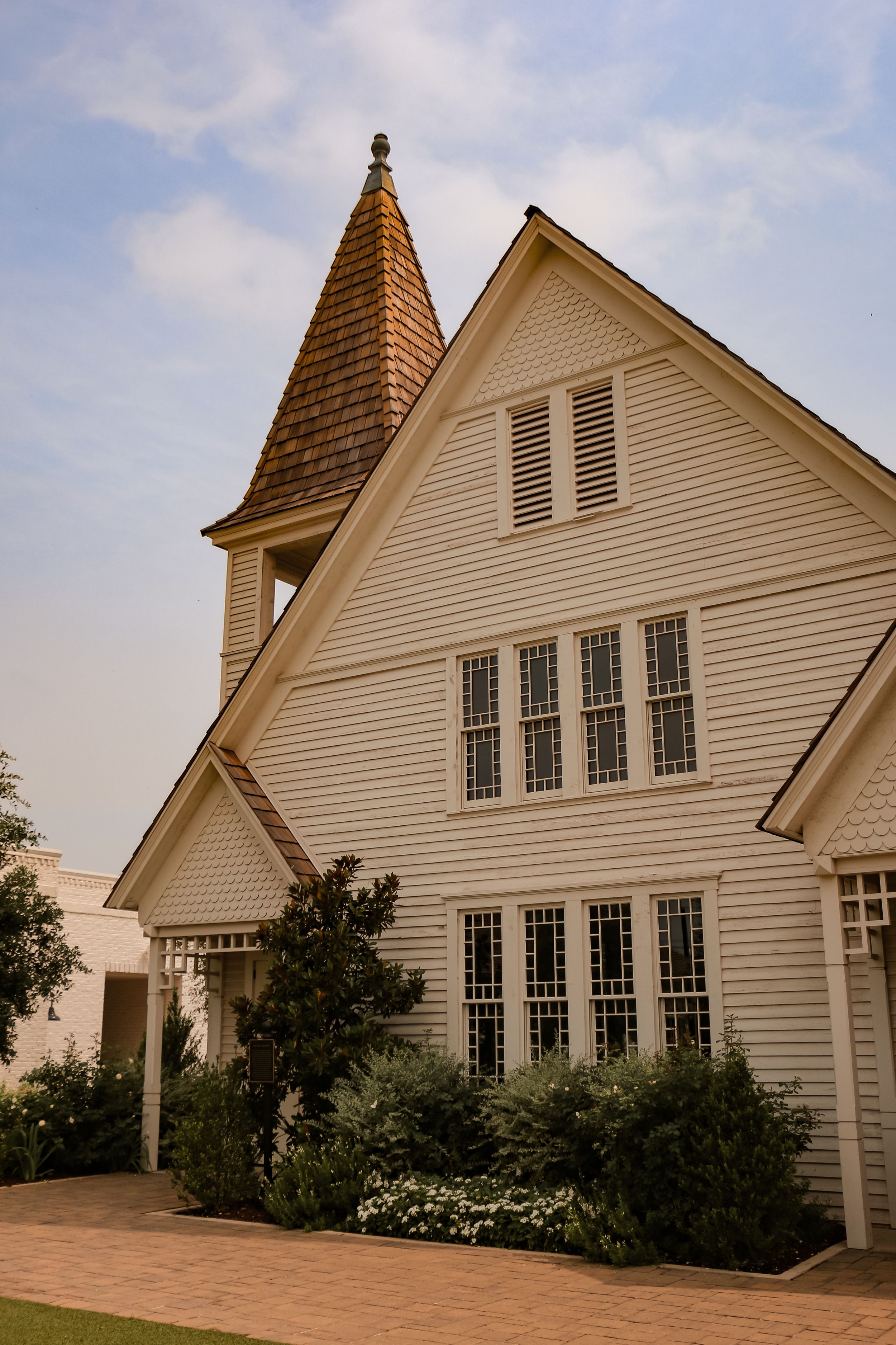 Classic white church with tall spire and multiple windows in traditional architectural style.
