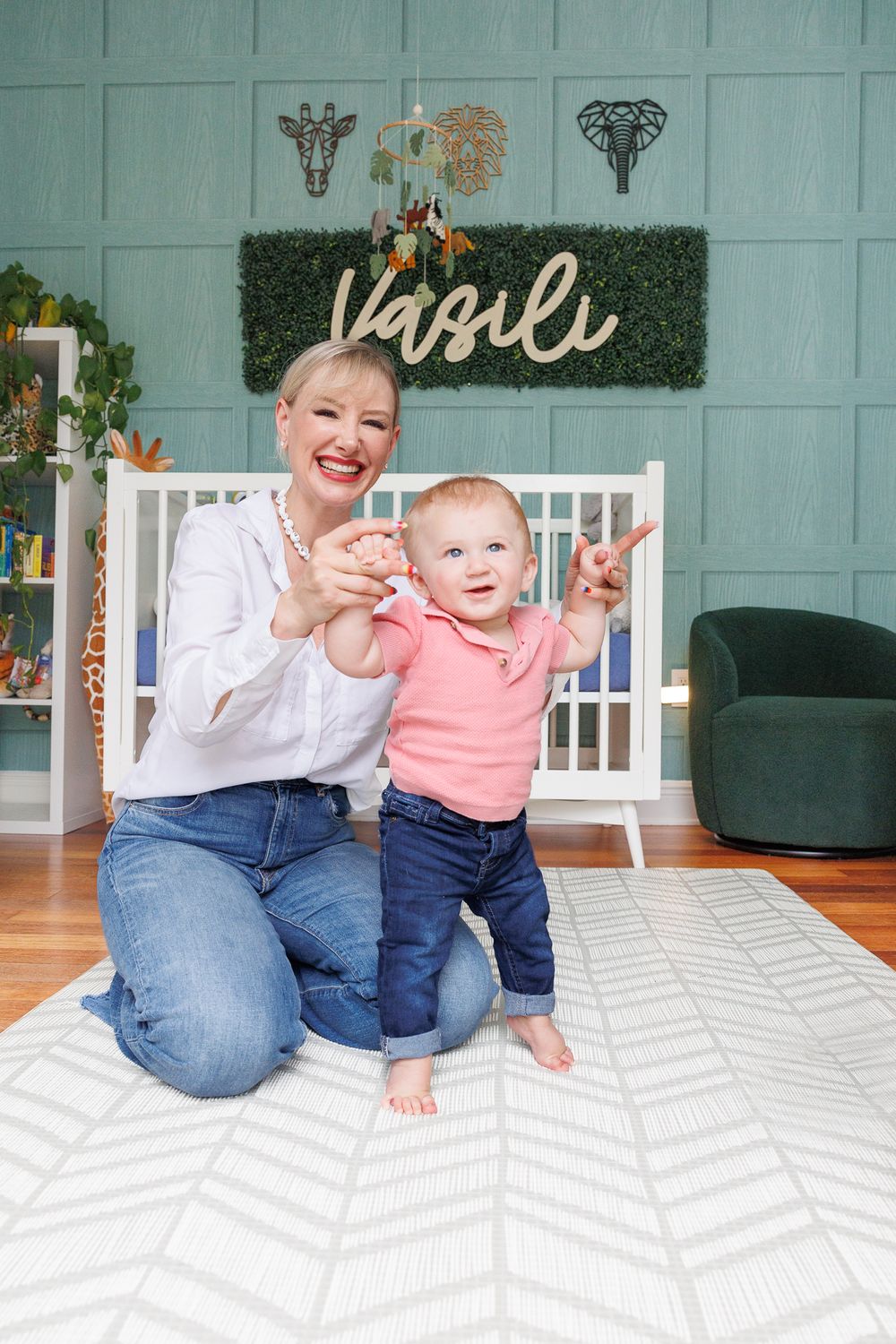 A joyful moment shared between baby and parent in a decorated nursery with decorative wall art.