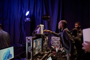 DJ equipment and lighting setup at a nighttime event with blue backdrop.
