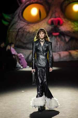 Black leather outfit with white fur trim presented against dramatic monster-themed backdrop.