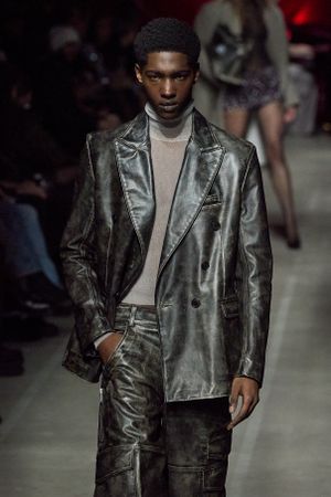 Metallic silver blazer and cargo pants combination showcased on fashion runway.