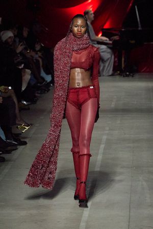 Burgundy monochromatic outfit featuring textured scarf and fitted pants on catwalk.