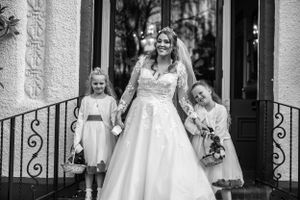 Black and white wedding portraits captured in front of an elegant doorway.