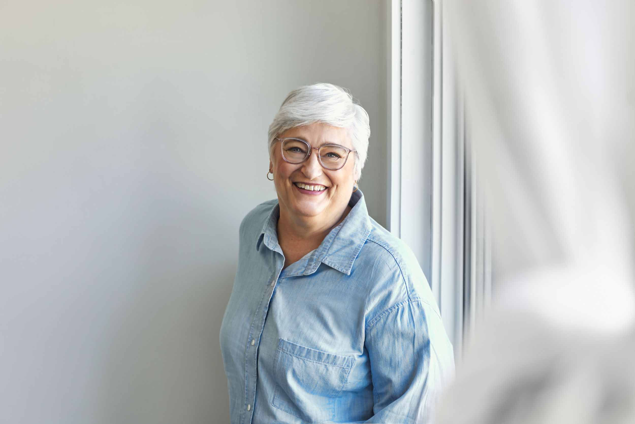 Portrait series showing a person in a blue shirt smiling and posing against a white background.