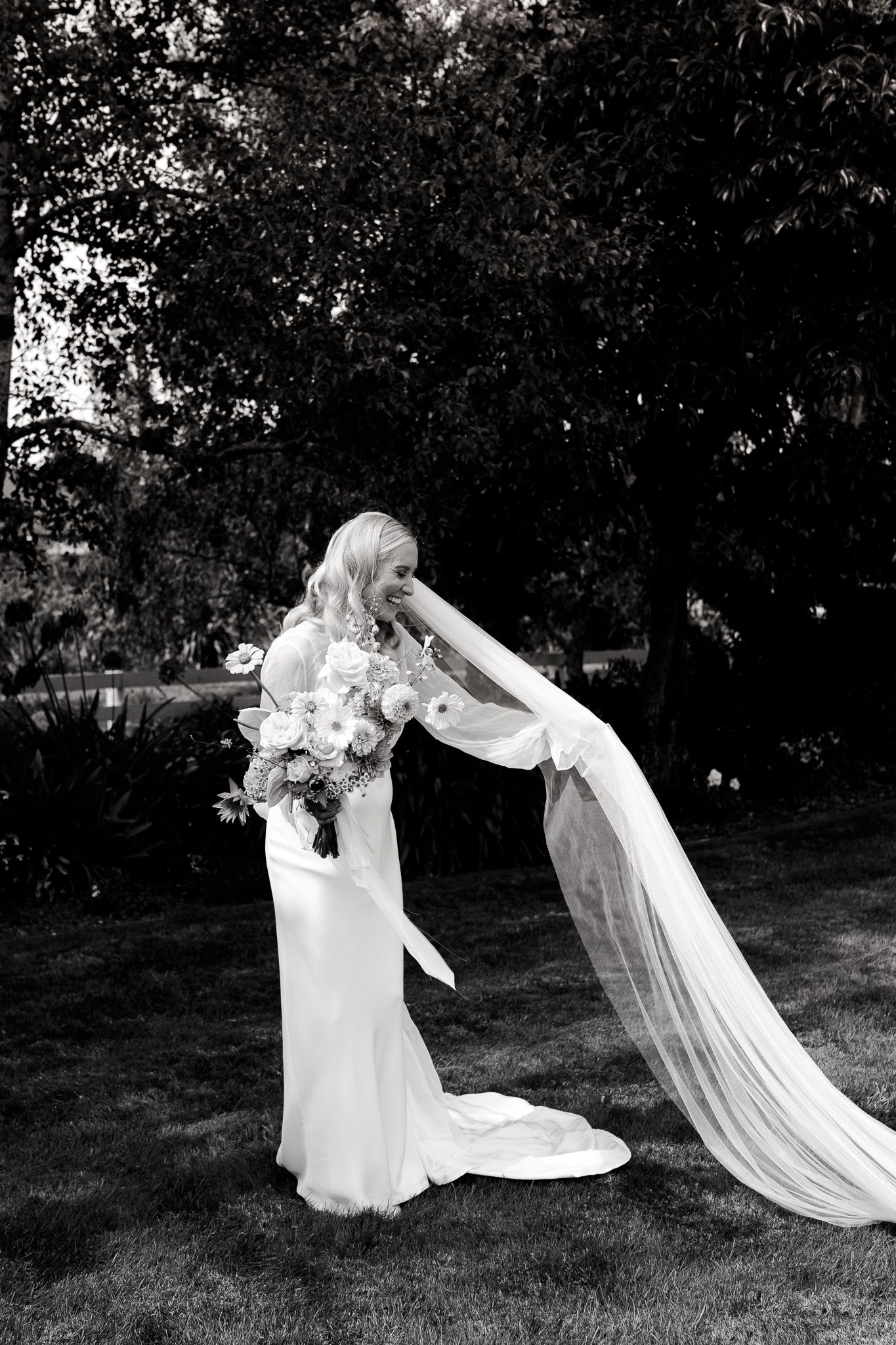 A candid wedding photo of a bride fixing her veil