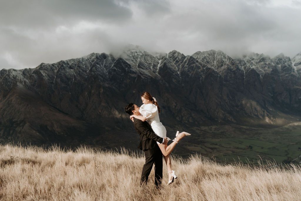 A landscape wedding portrait of a couple in front of a stunning Queenstown mountain landscape.