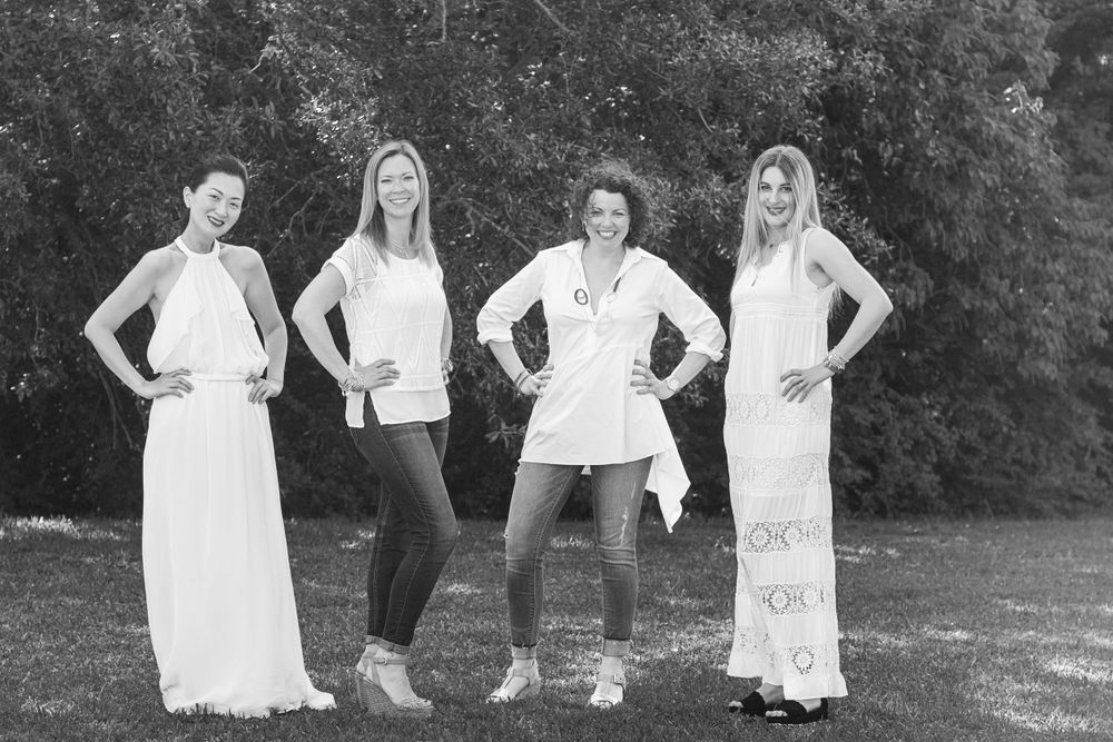 black and white of 4 adult women friends in a filed