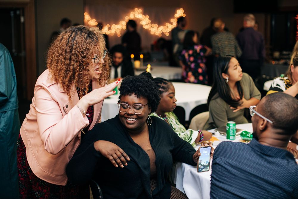 Guests enjoying a lively celebration at an indoor party with string lights and decorations.