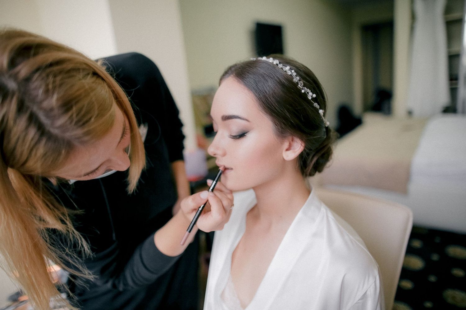 Makeup artist applying cosmetics during bridal preparation.