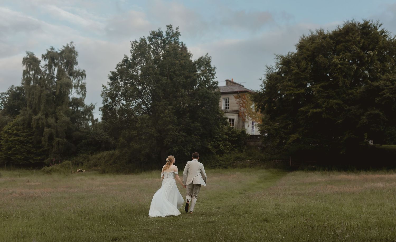 A scenic wedding photo series showing figures in formal attire against a rustic outdoor landscape with trees and grass.