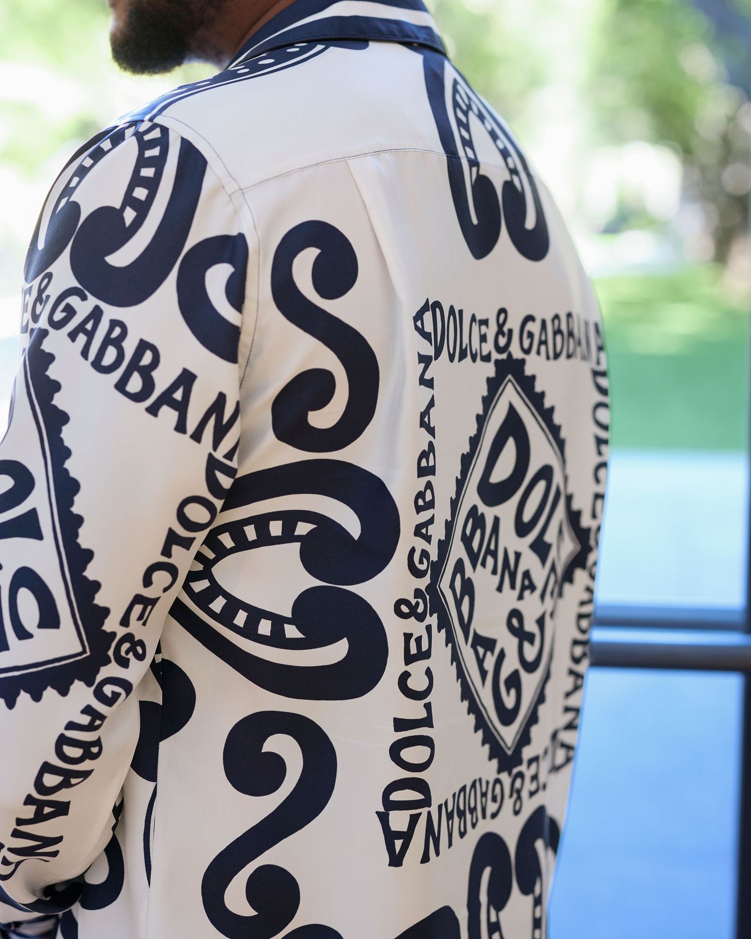 Designer jacket featuring bold black and white typography pattern.