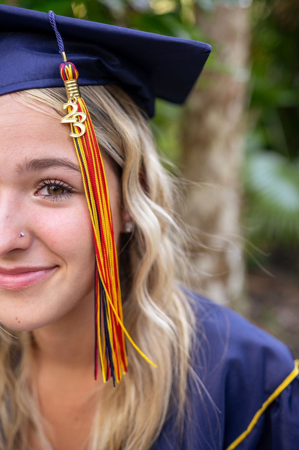 Senior girl graduation photoshoot session in cap and gown smiling standing in trees park sunset Melbourne Cocoa Vero Florida Brevard County