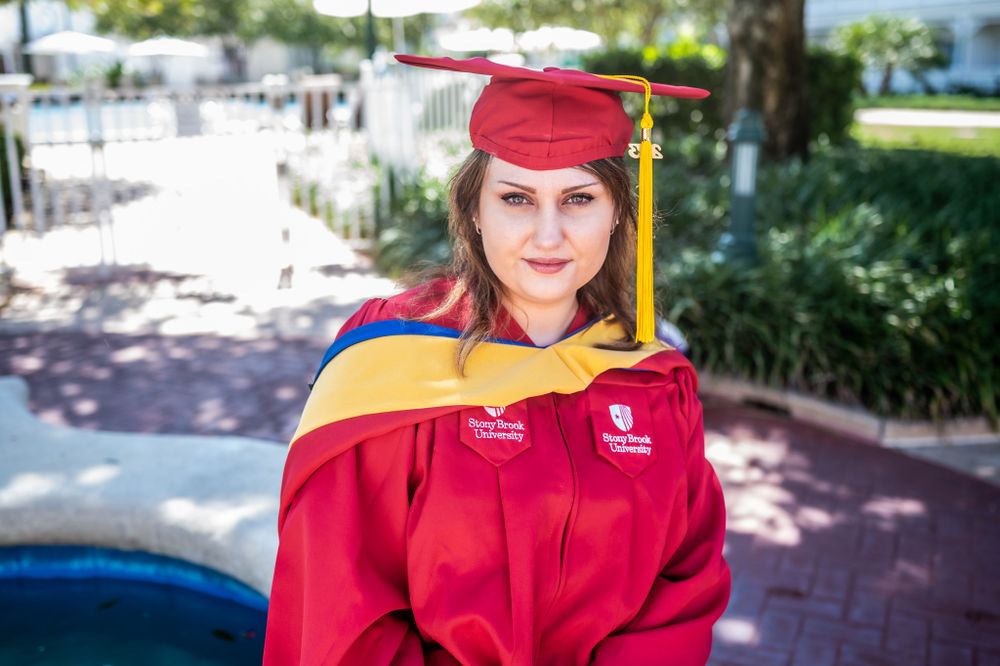 Senior girl graduation photoshoot session smiling in cap and gown  masters Disney world Orlando Melbourne Cocoa Vero Florida Brevard County