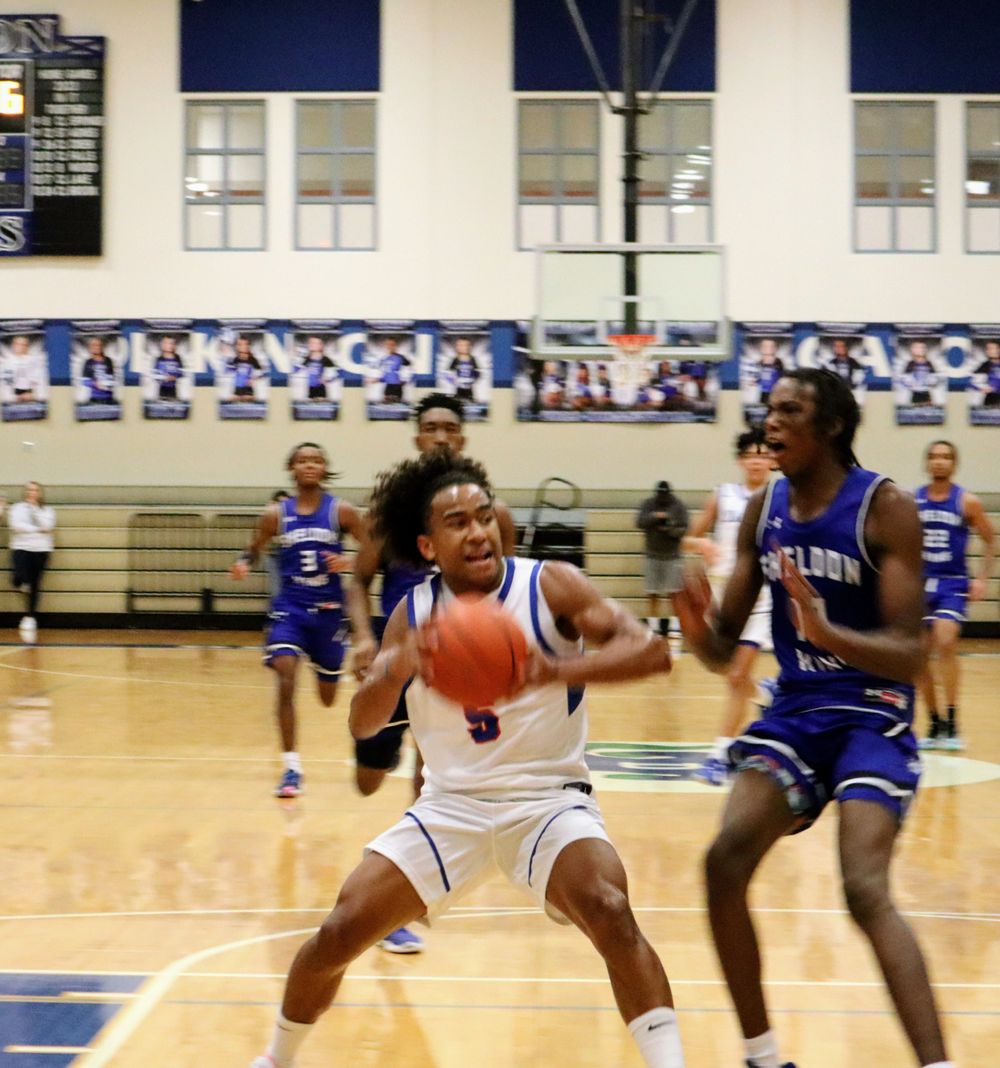 Players battle for position during an intense basketball game on the hardwood court.