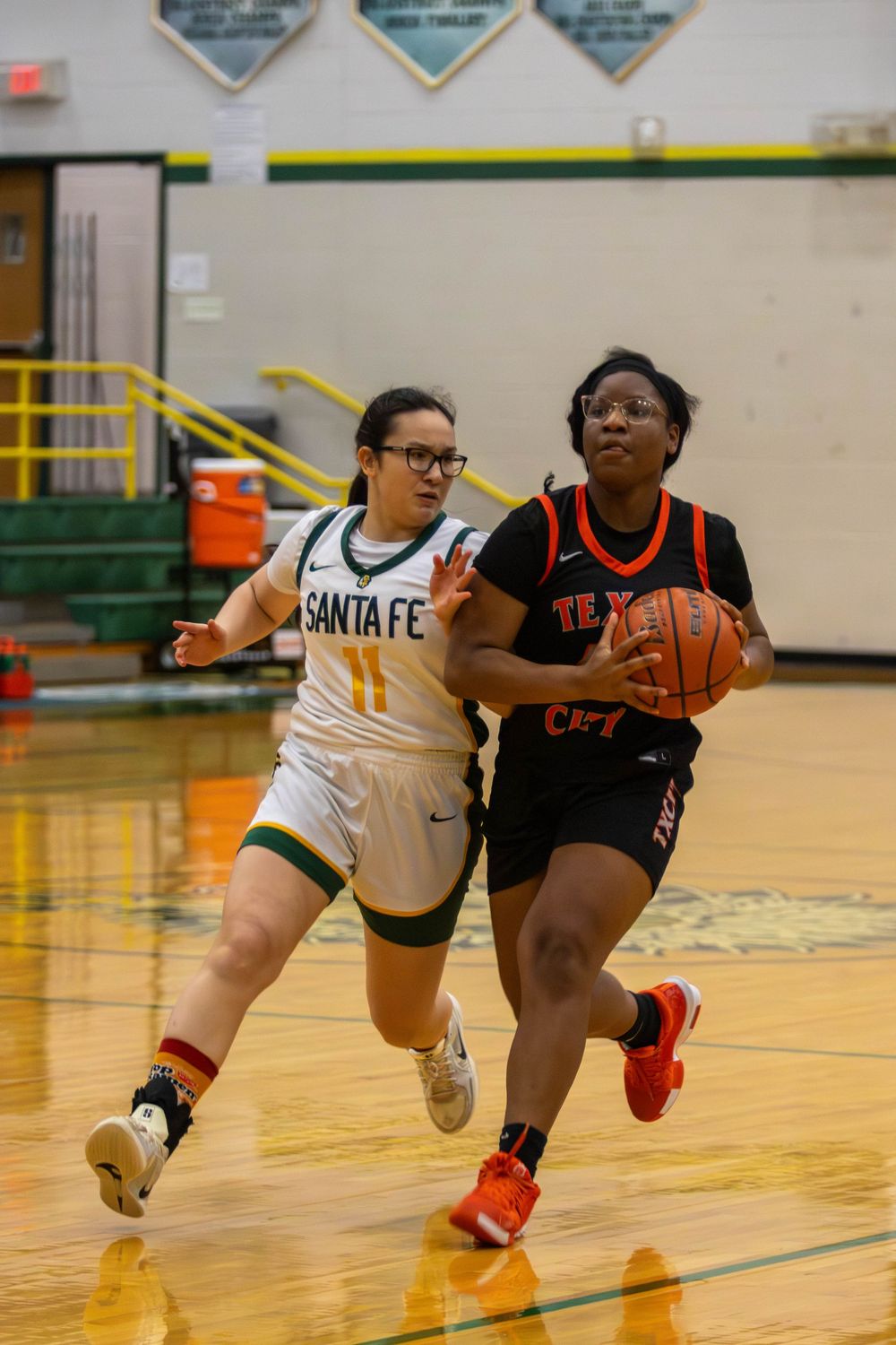 Basketball players sprint after a loose ball during an intense game sequence.