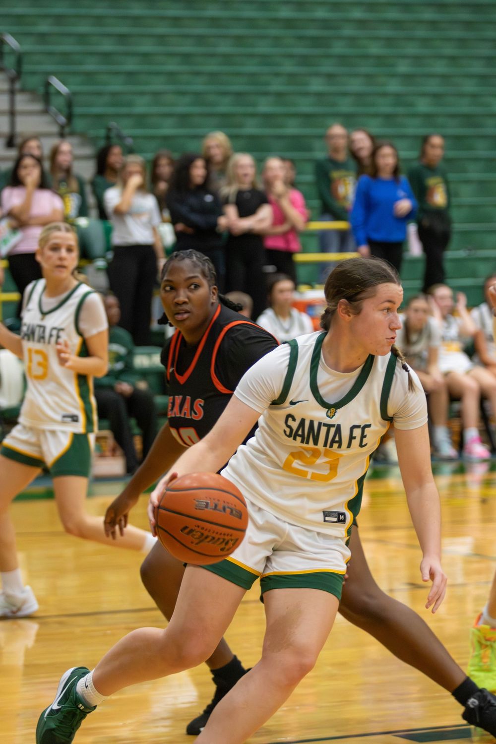 Basketball players from Santa Fe and opposing team compete during intense game action.