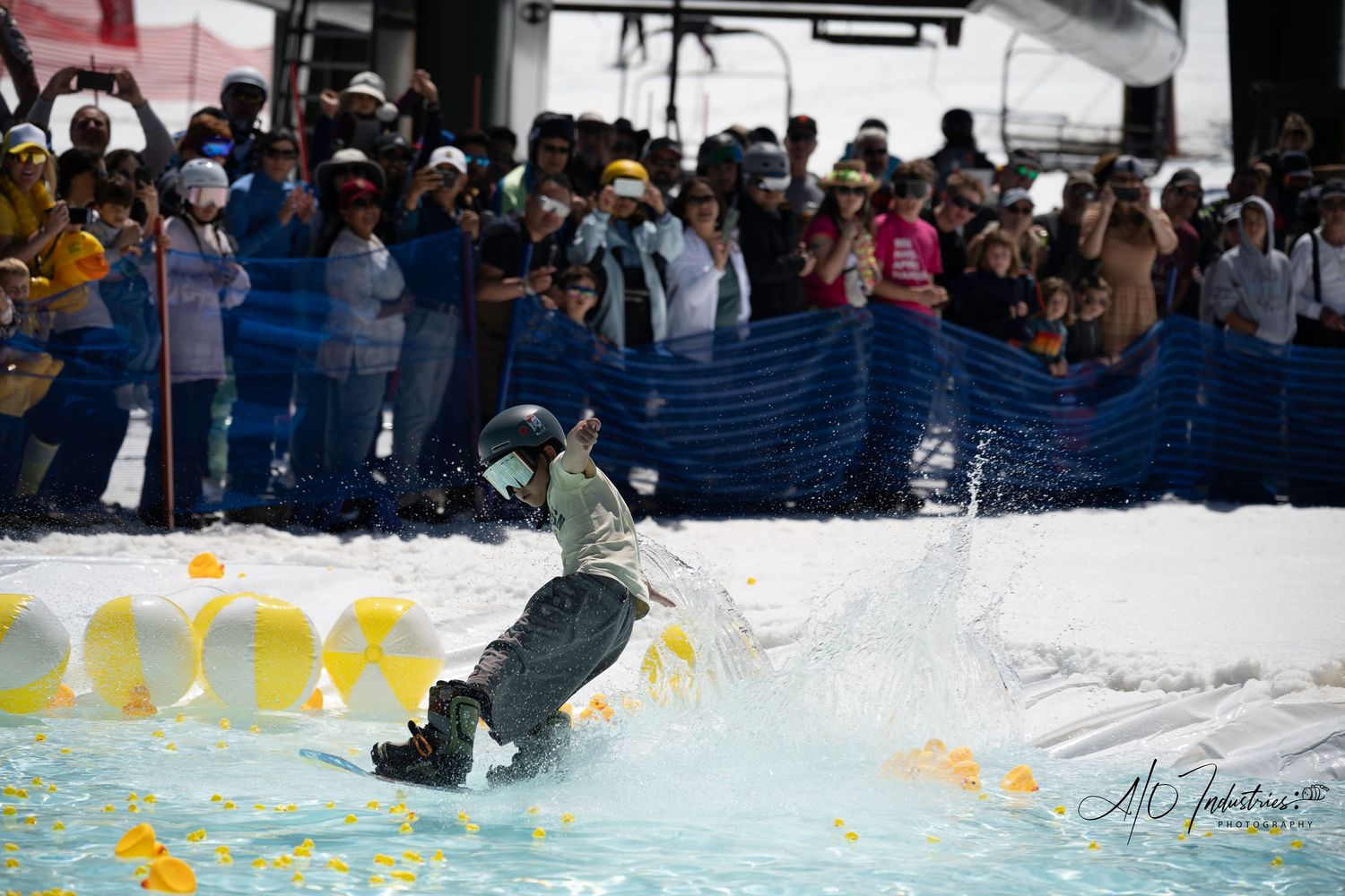 Snowboarder performing a splash landing in pool during a winter sports event.