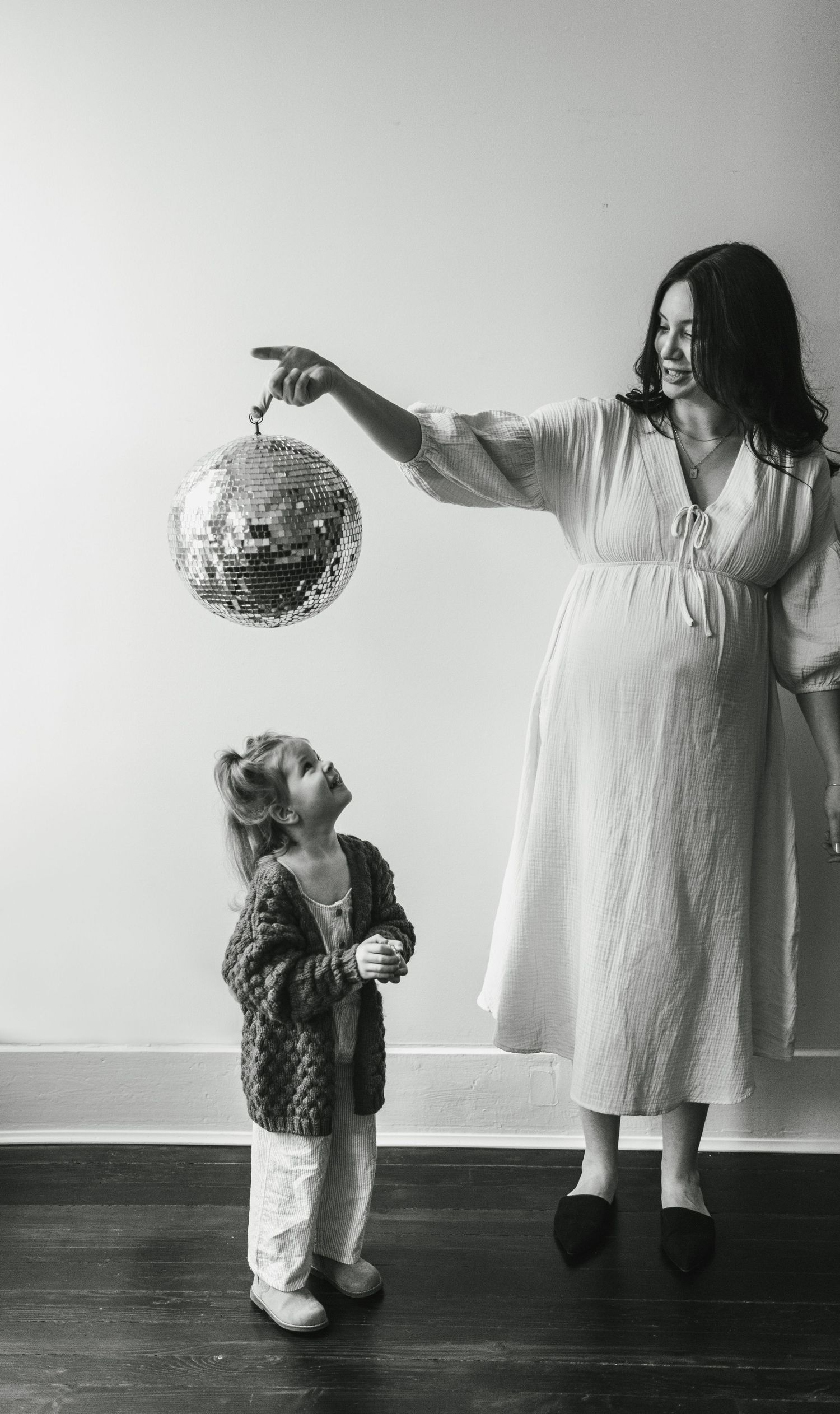 Intimate family moment showing parents embracing their newborn baby in cozy sweaters.