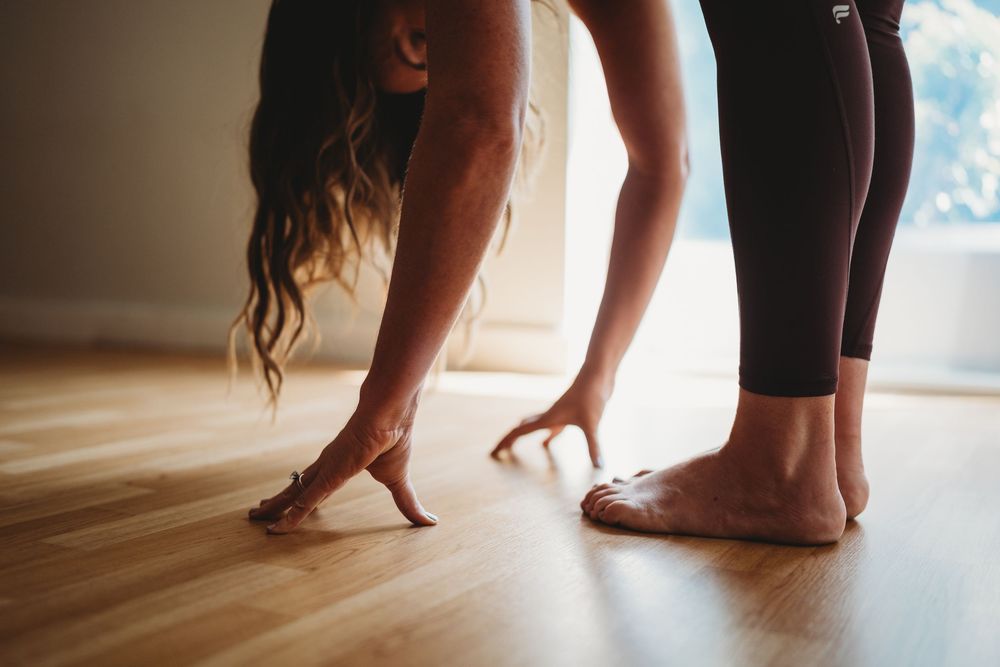 Bare feet of two people standing on a wooden floor in a sequence of movement steps.