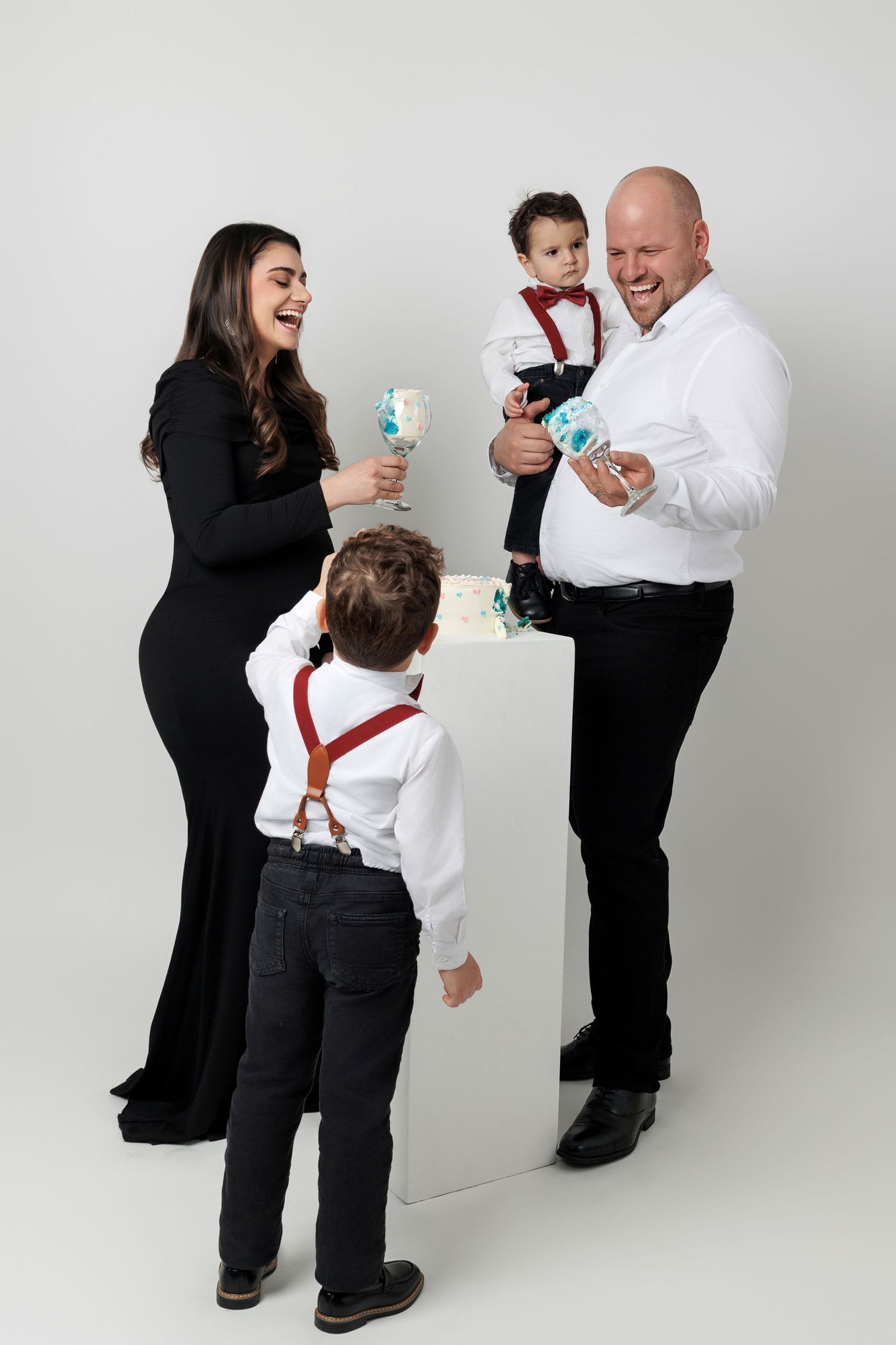 A series of four progressive photos showing a parent and child playing and laughing together in formal attire.