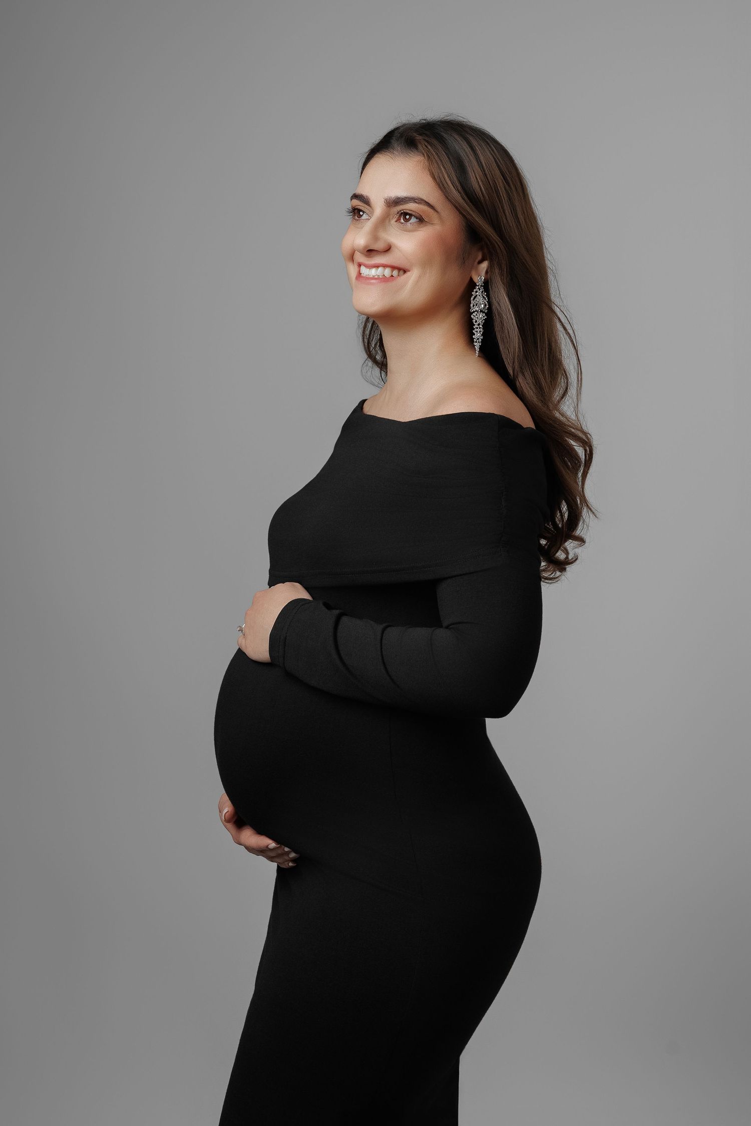 A series of fashion portraits showing different poses in a black sweater against a gray studio backdrop.