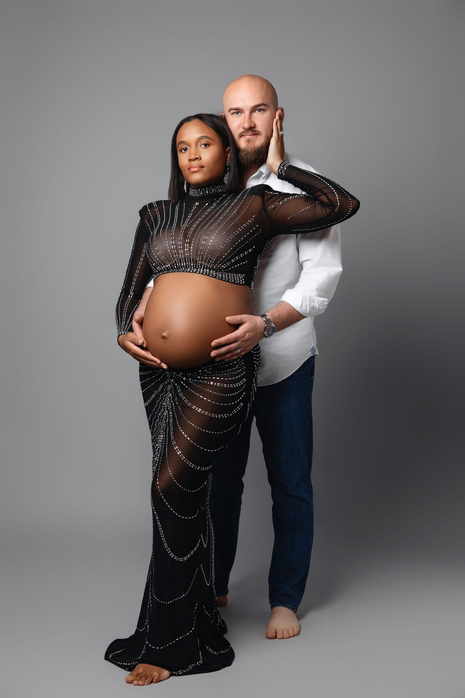 Artistic maternity portrait featuring couple with sparkly black gown.