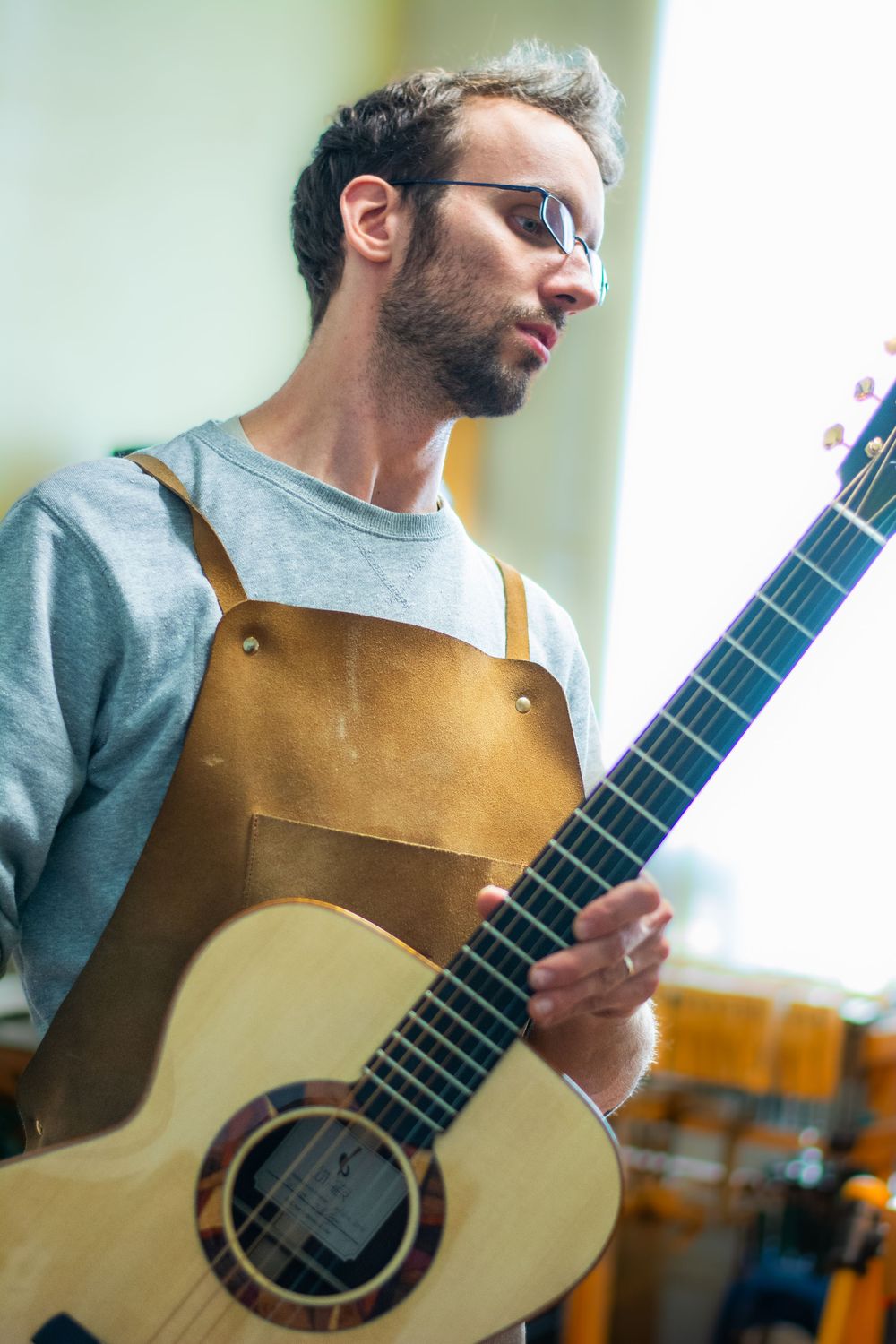 Un artisan luthier qui pose devant une camera dans son atelier à Bruxelles