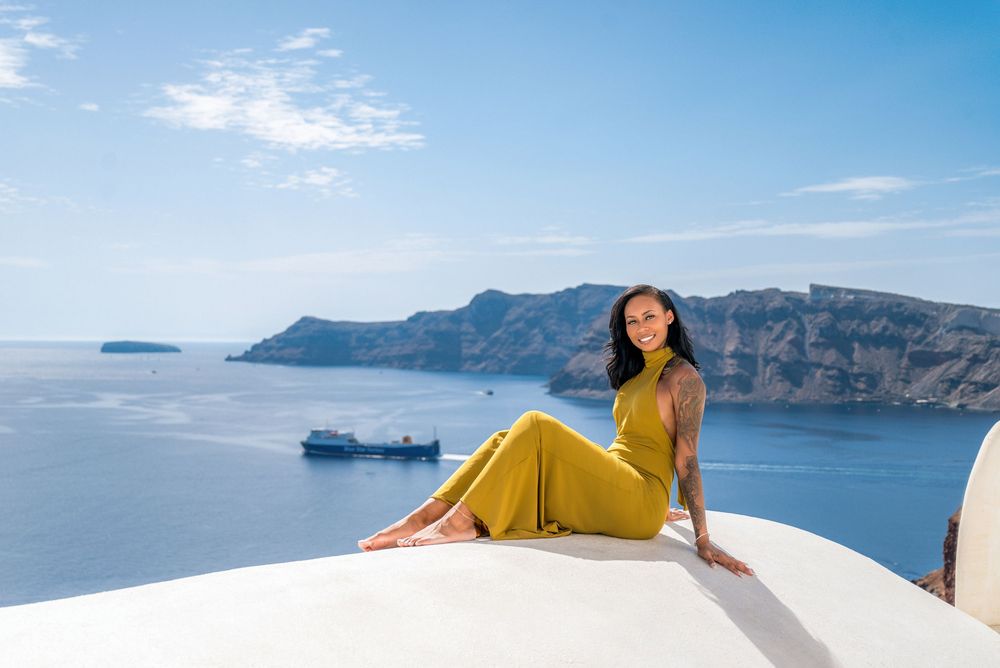 A scenic panoramic view of Santorini's white buildings and blue waters along the Mediterranean coastline.