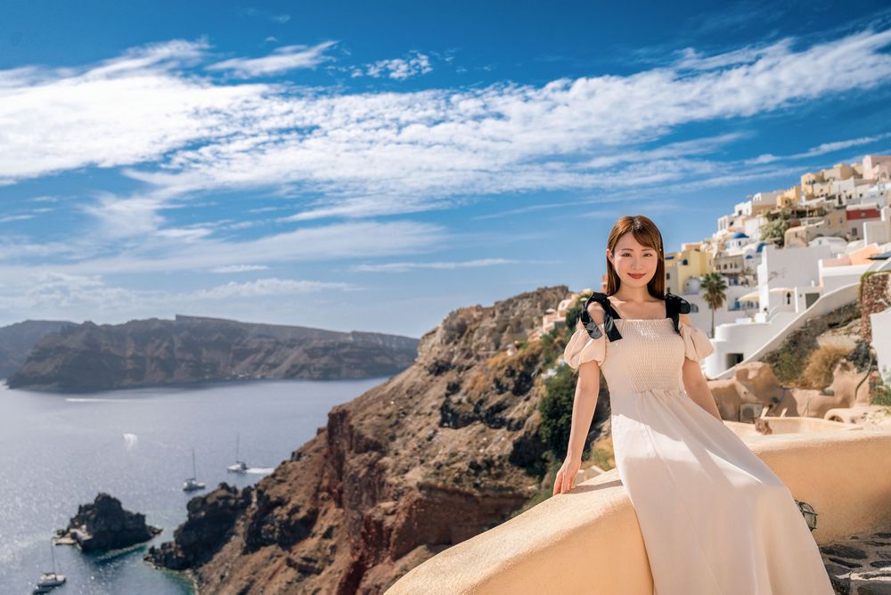 A stunning panoramic view of Santorini's white buildings perched on cliffs overlooking the blue Aegean Sea.