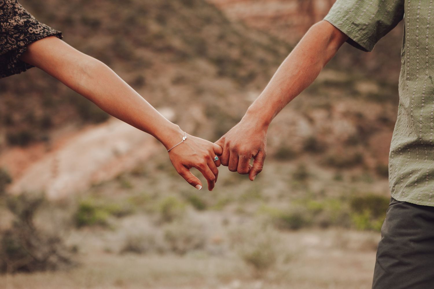 Monument engagement photos.
Two people hold hands while standing on a rocky outdoor trail in warm natural lighting.