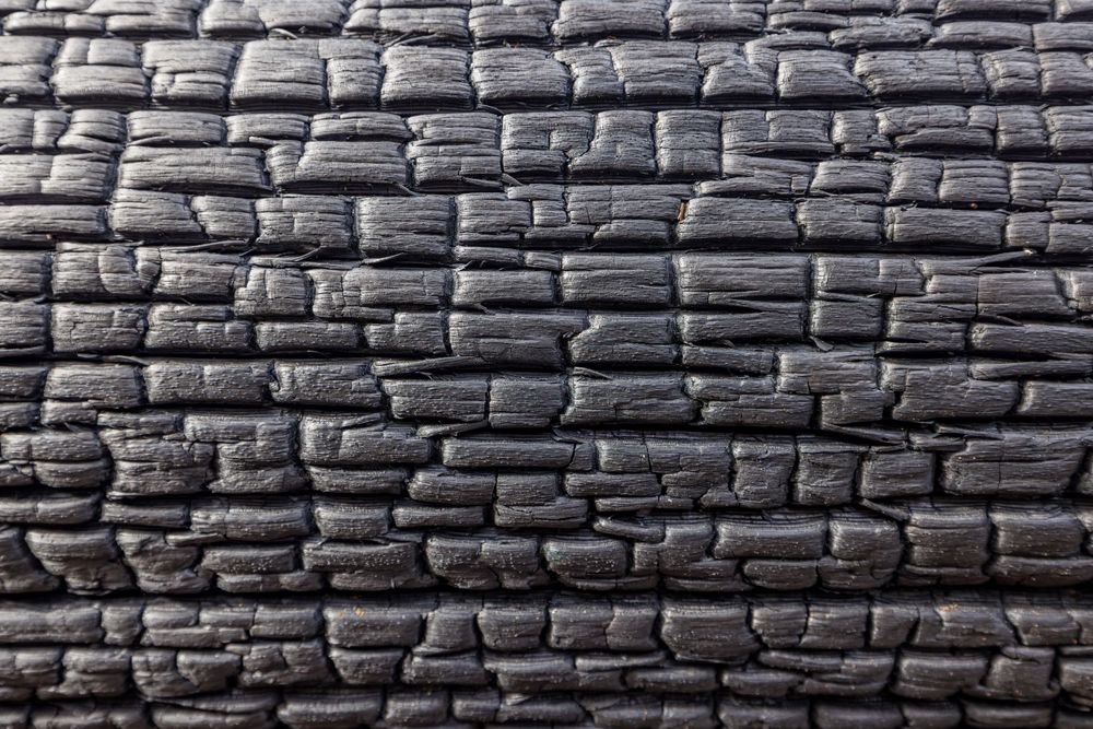Textured pattern of dark stone brick wall in close-up detail.