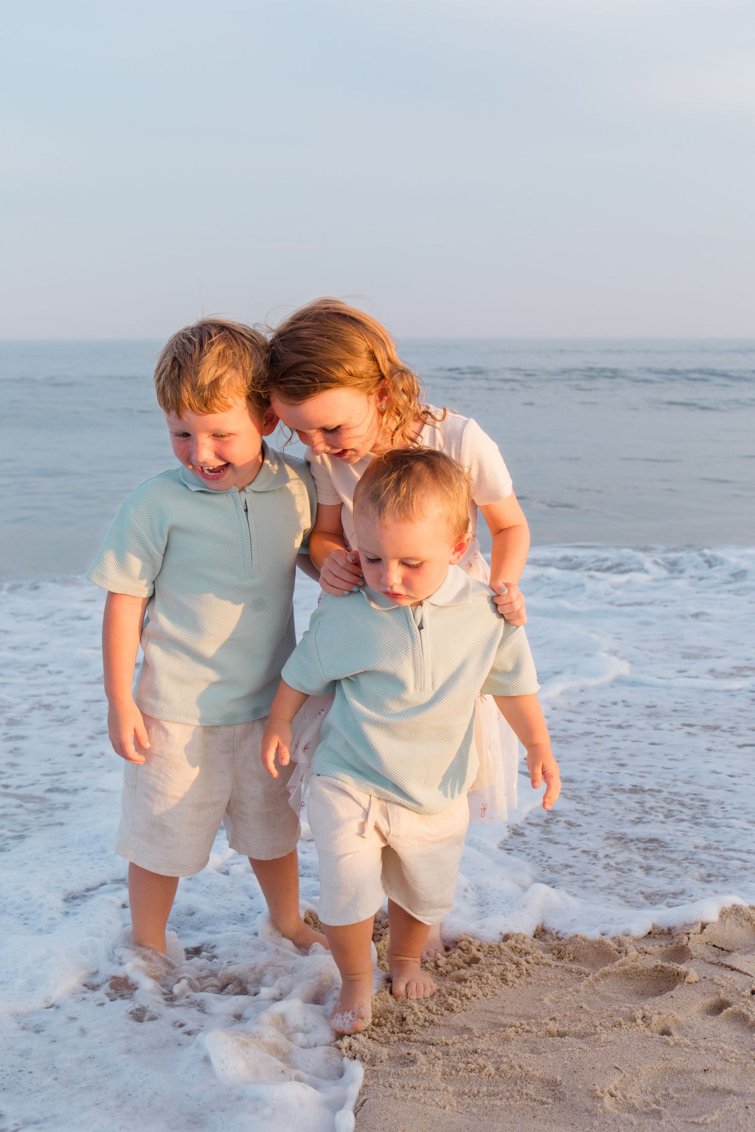Playful beach scene with loved ones enjoying the sand and surf at sunset.