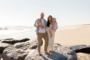 Family enjoying a beach day together on sandy shores with ocean waves by Hamptons photographer.