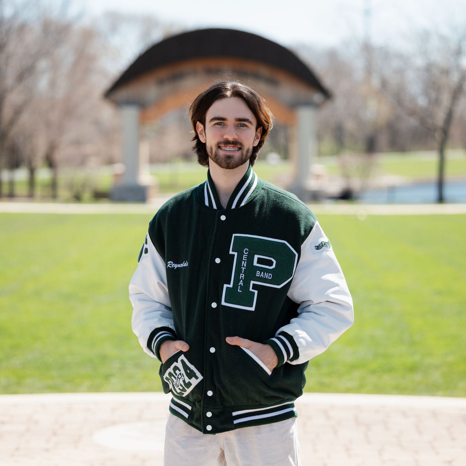 Classic varsity letterman jacket with P letter displayed in outdoor park setting.