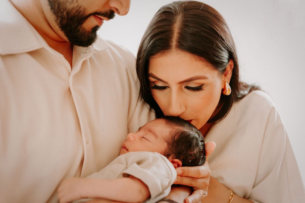 Family sharing tender moment with newborn baby in cream outfits.
Altona Family Photographer Melbourne