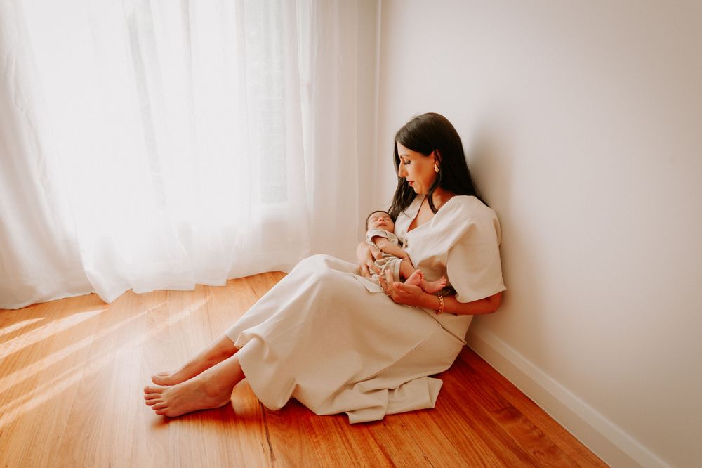 Quiet moment on hardwood floor with parent holding sleeping baby in white dress.
Altona Family Photographer Melbourne