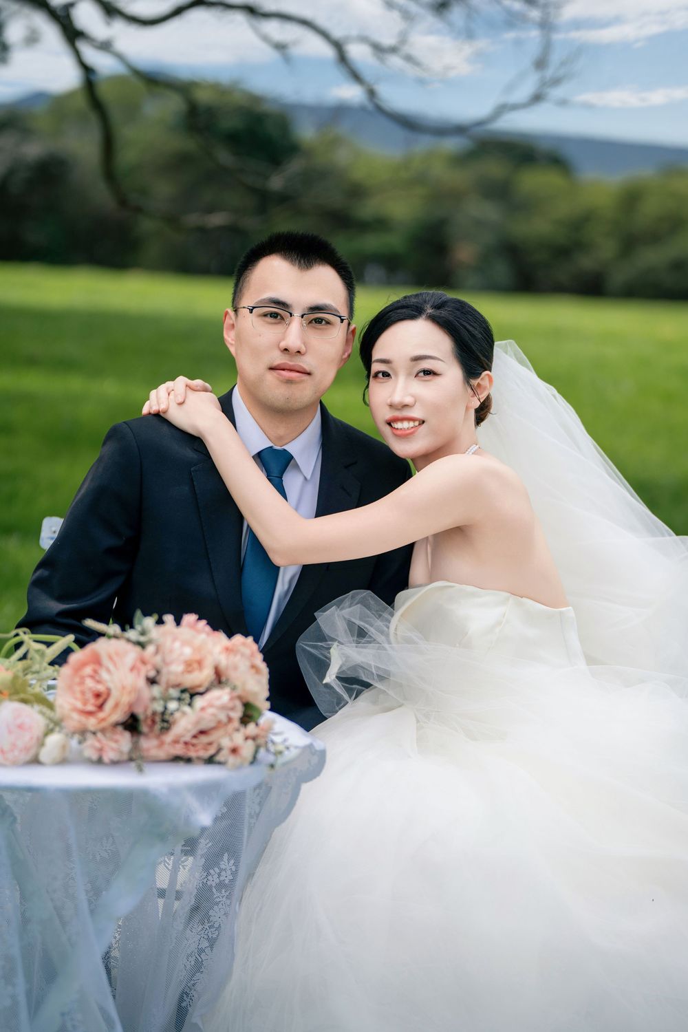 Bride and groom enjoying a romantic park picnic setup surrounded by nature in Auckland.
