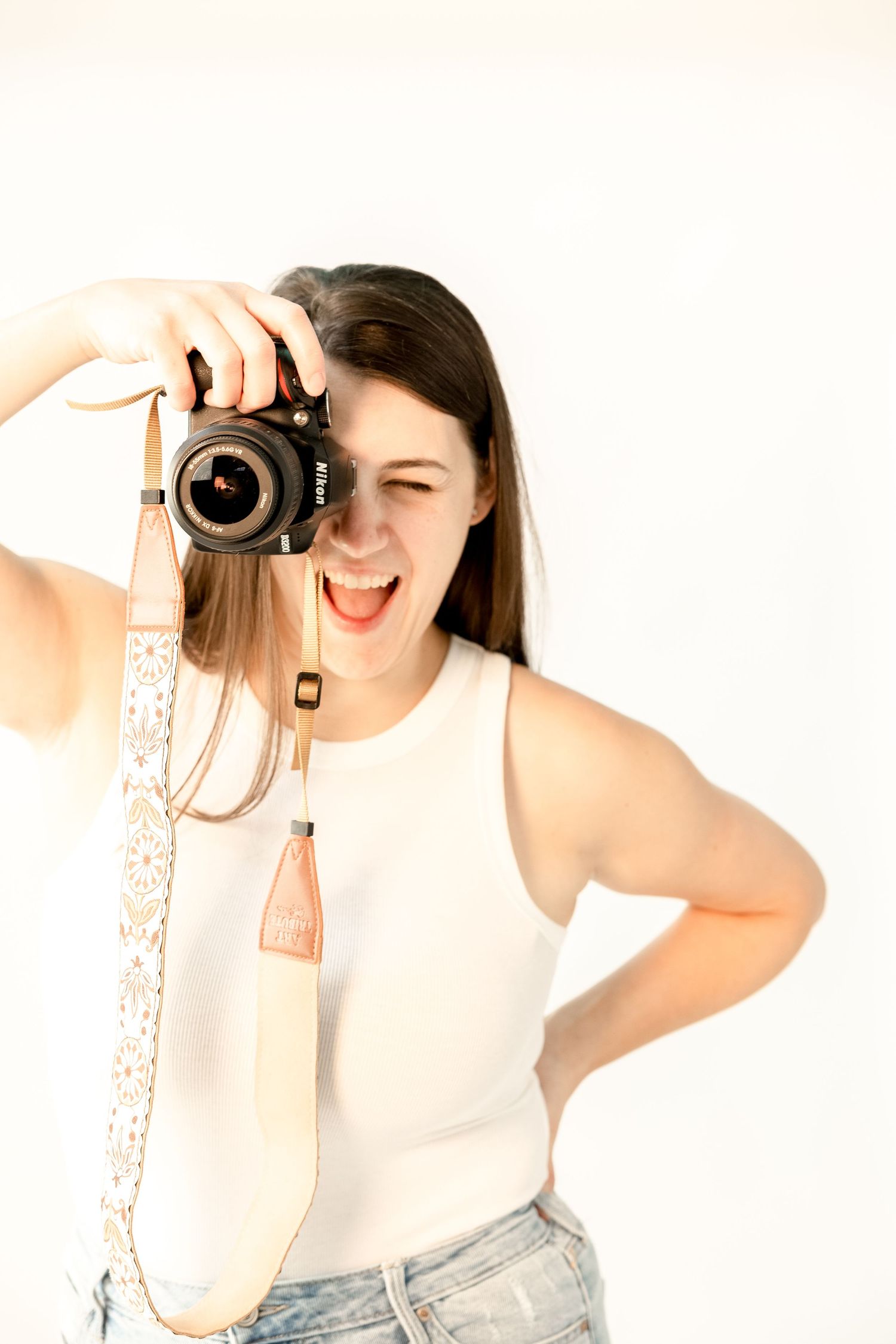 Creative sequence of photographer taking self portraits with professional camera against white background.