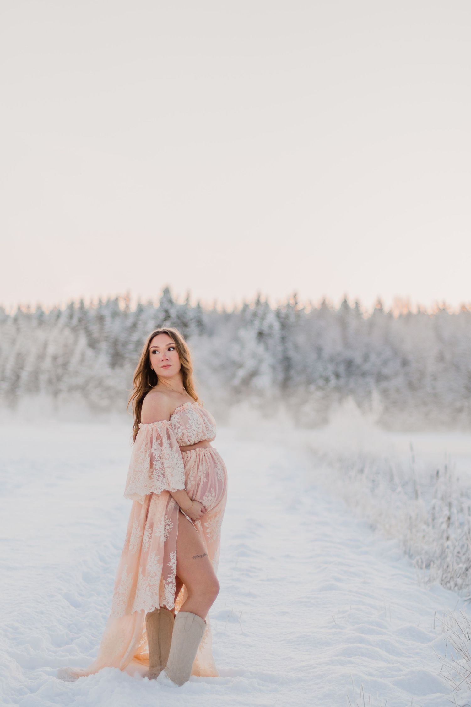 A floral crop top and high-waisted beige pants create a stylish summer outfit in a golden meadow setting.