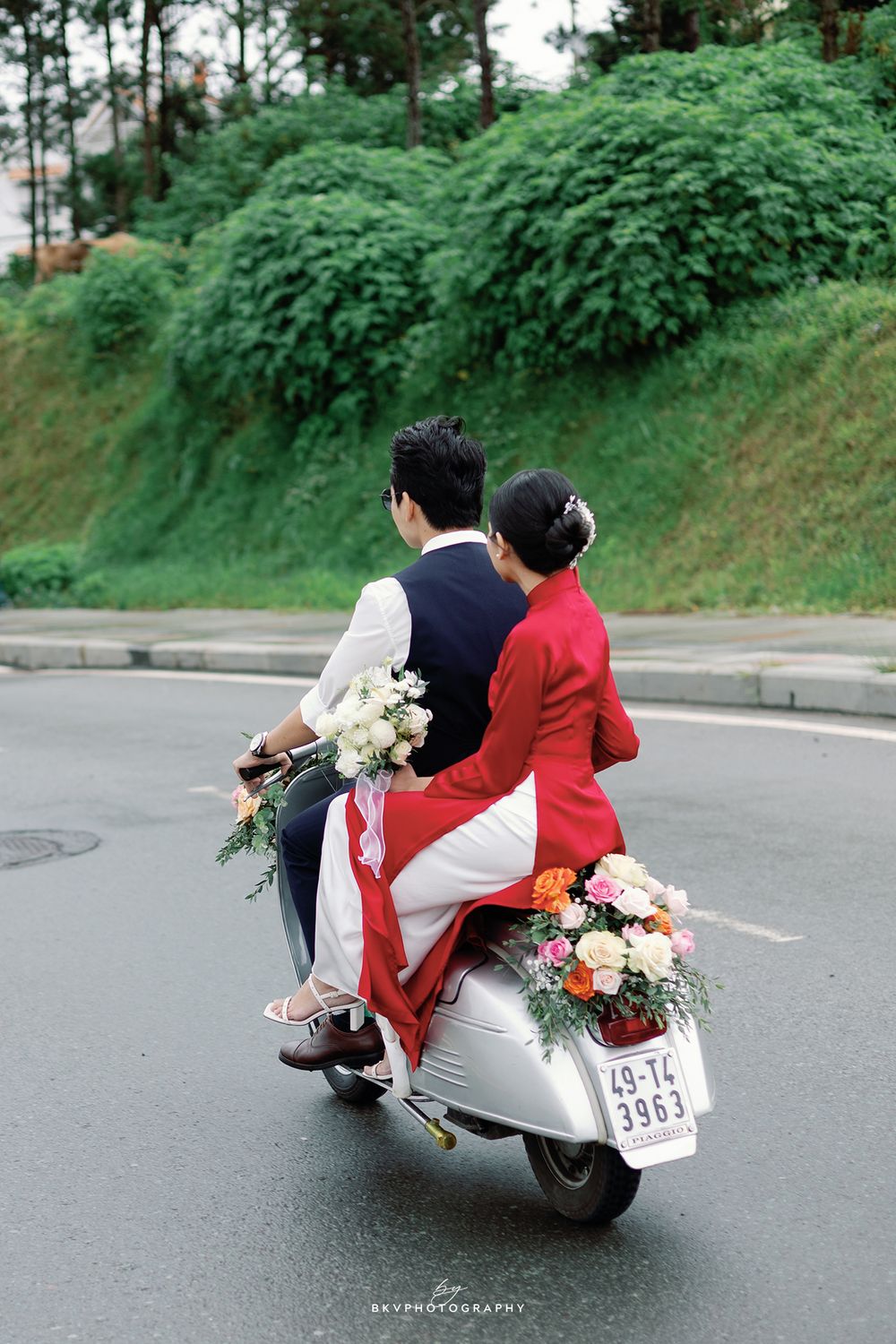 A black and white wedding photo showing a tender moment as the bride holds a bouquet of white flowers.