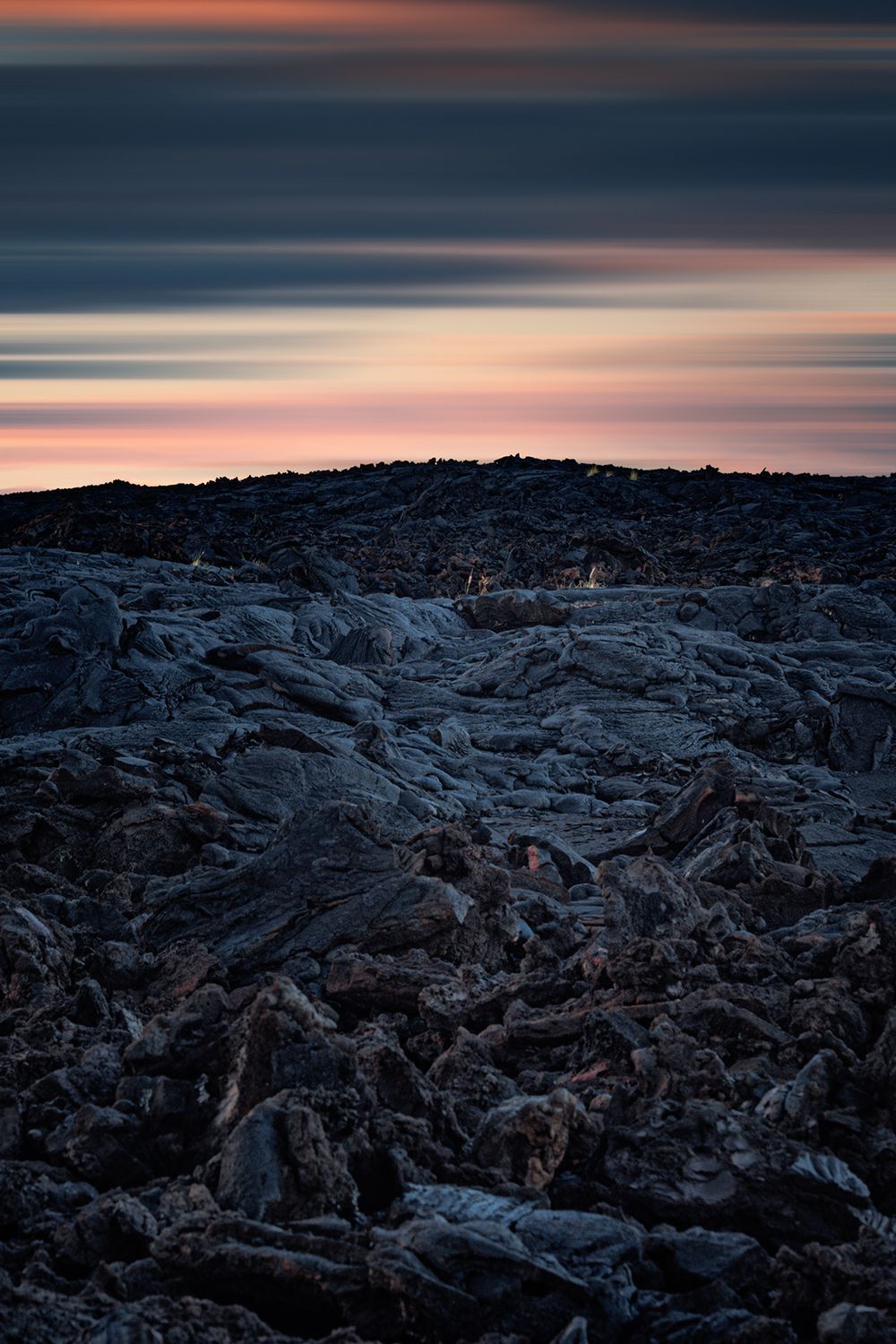 Rocky terrain silhouetted against a pink and blue twilight sky.