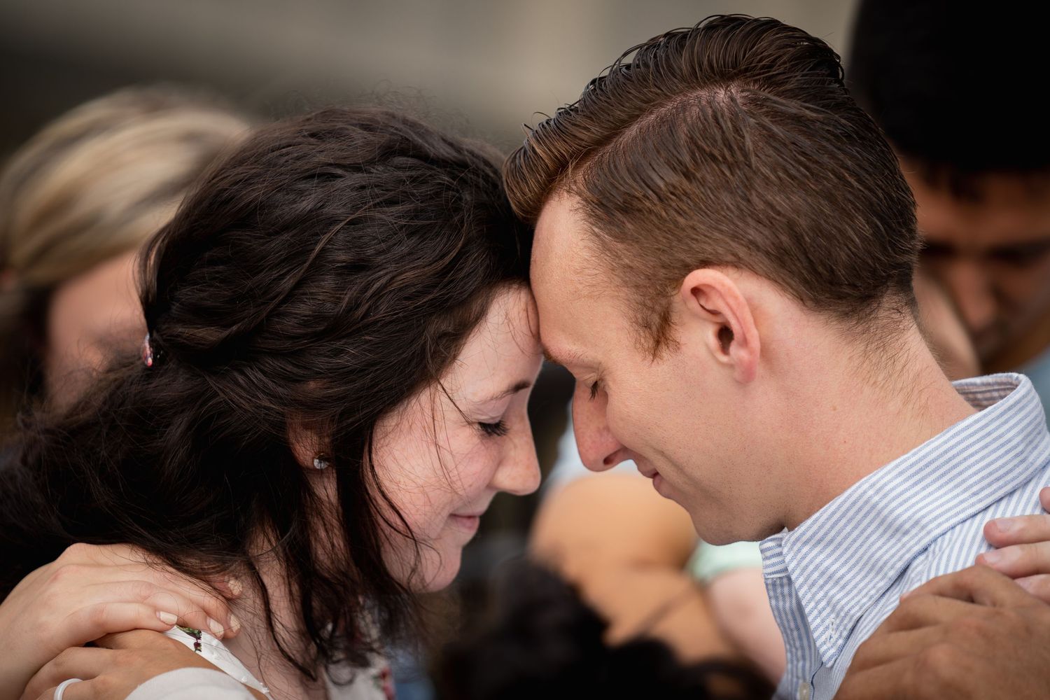 Intimate forehead touch between couple in tender embrace.