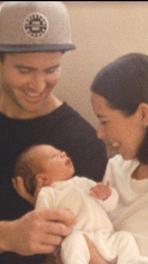Intimate family moment with a newborn baby in a warm-toned indoor setting.