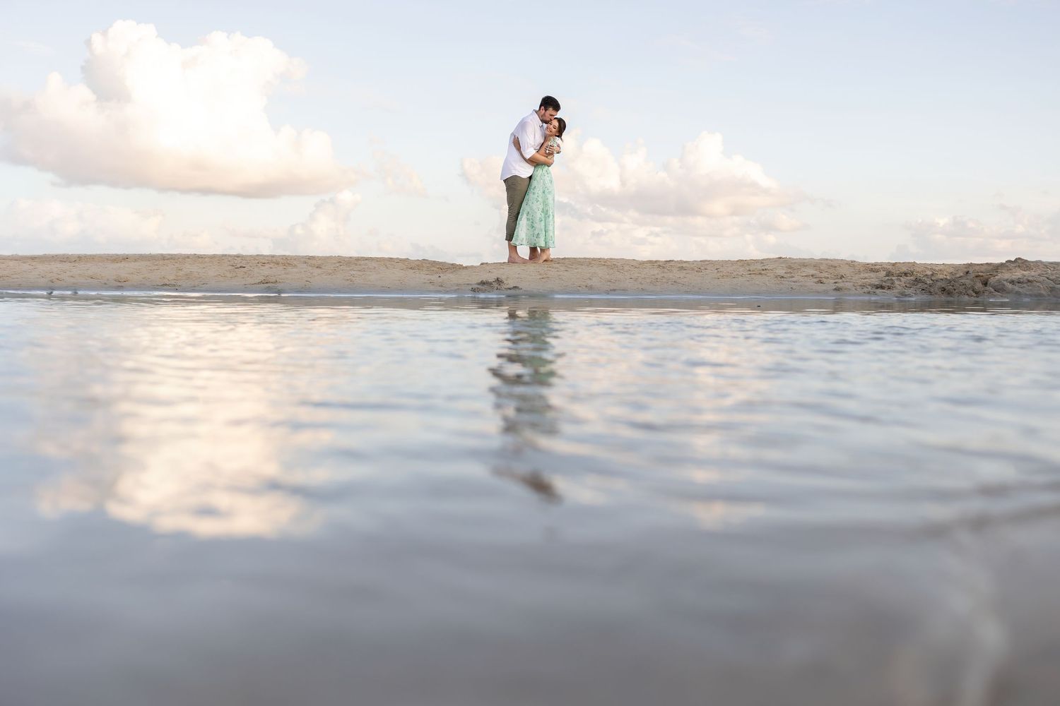 Romantic sunset embrace during Alexia and Scott’s engagement session on the beach in Isla Mujeres, Mexico.