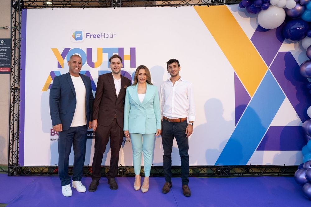 Group photo at FreeHour youth awards event with branded backdrop.