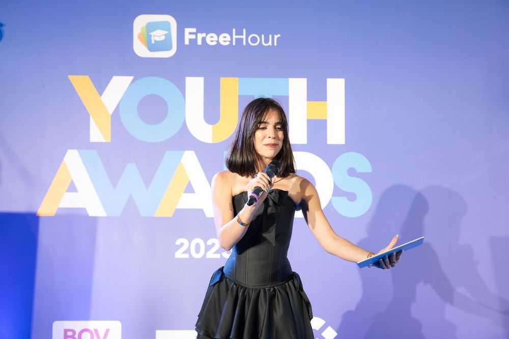 Event stage setup with blue lighting and geometric backdrop displaying FreeHour branding at youth awards ceremony.