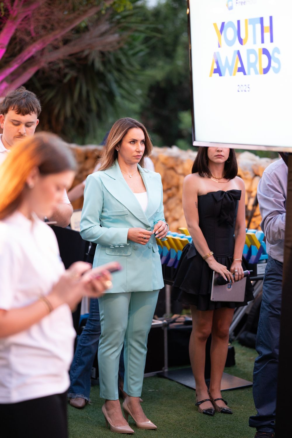 Casual outdoor gathering with attendees in business attire at youth awards event.