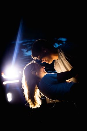 A silhouetted horse and rider illuminated by bright spotlights against a dark background creates a dramatic effect.
