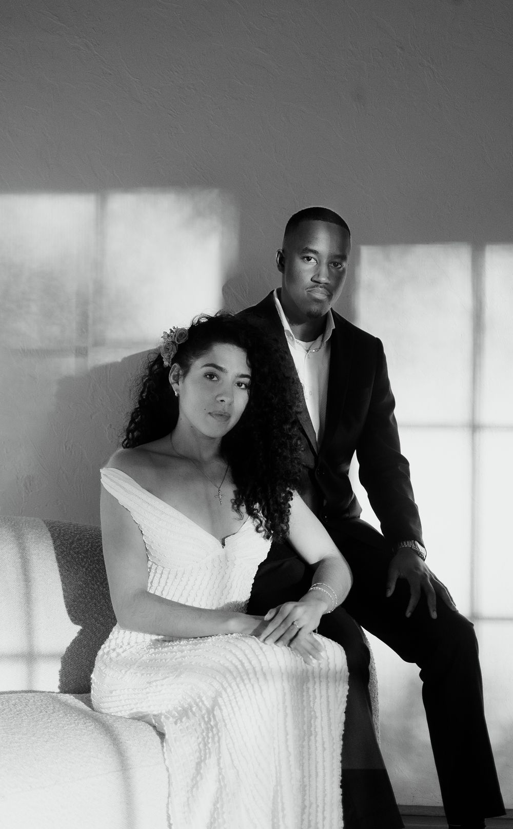 Black and white artistic wedding photo series showing intimate poses between a bride in a white dress and groom in a suit.