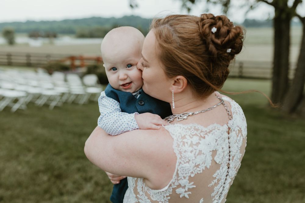 Tender moments between bride in lace gown and small child.